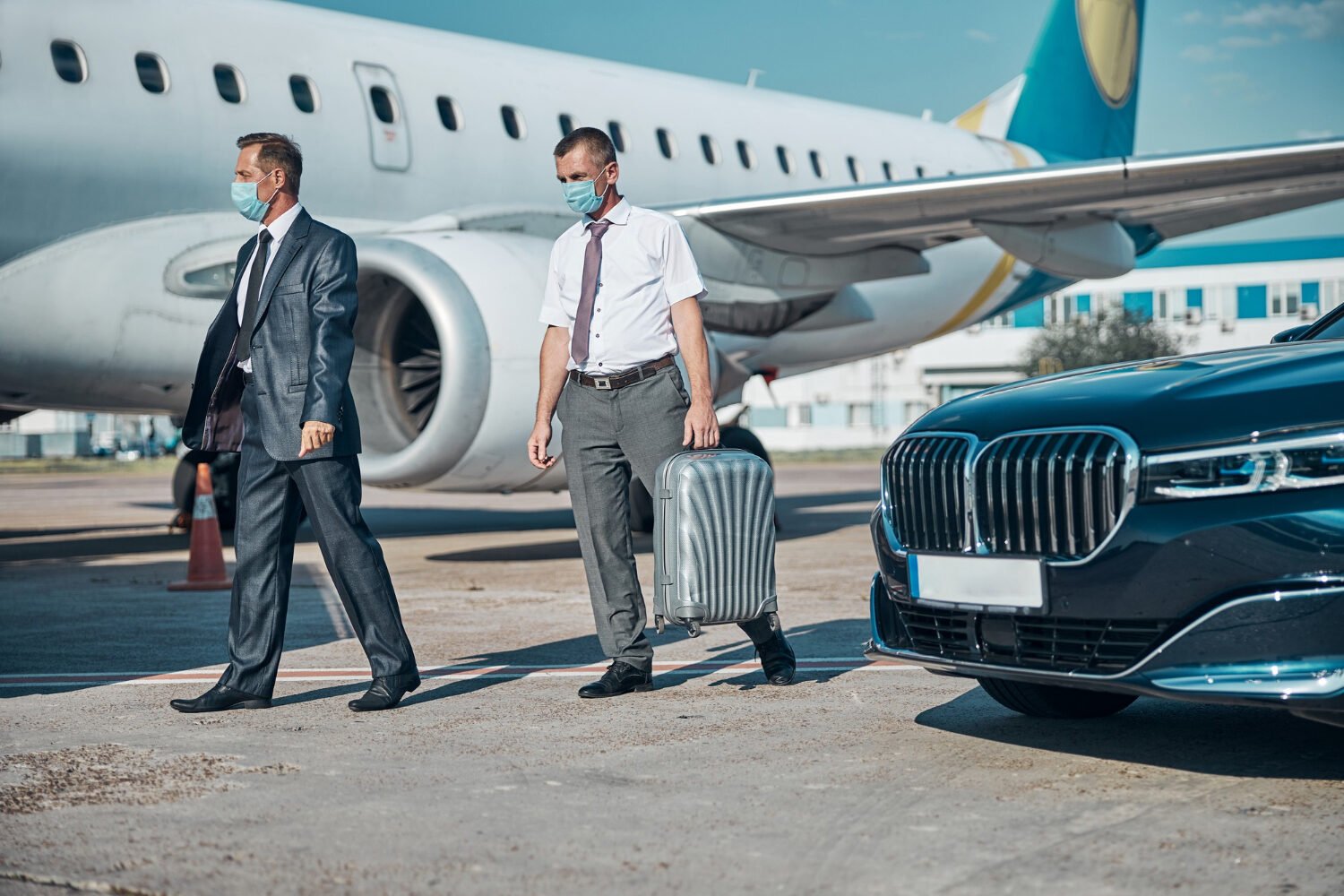 Business travellers walking to a private jet after a chauffeur transfer