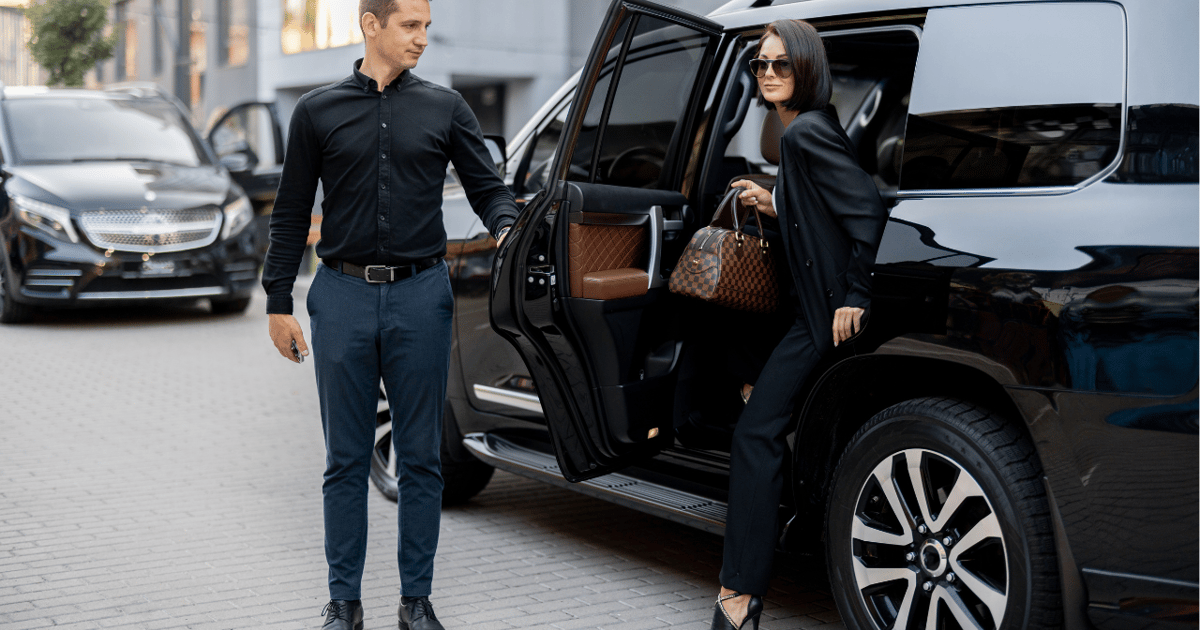 Chauffeur placing a suitcase into an executive people carrier in Alderley Edge