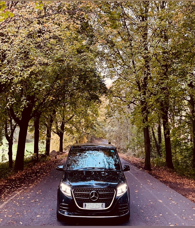 Black Mercedes executive saloon on a tree lined road near Altrincham