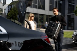Royale Rides chauffeur assisting passengers with luggage on an executive transfer