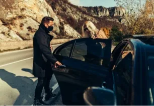 Royale Rides chauffeur opening the rear door of an executive car for a passenger