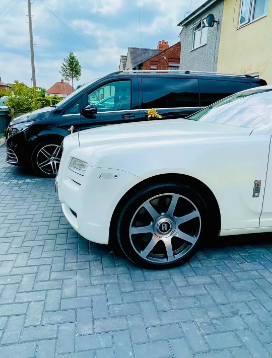 White Rolls-Royce and black Mercedes V-Class wedding fleet on a driveway for an Oldham wedding