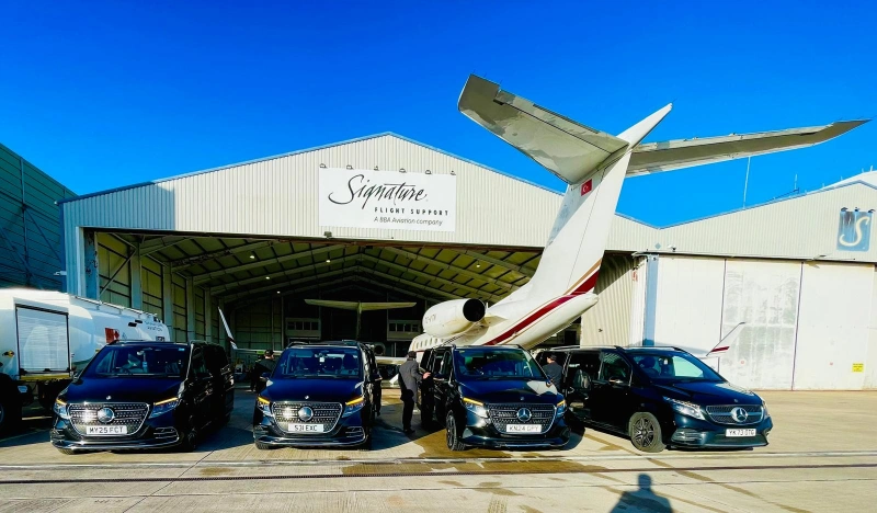 Royale Rides chauffeur car beside a private jet at Signature Aviation Manchester