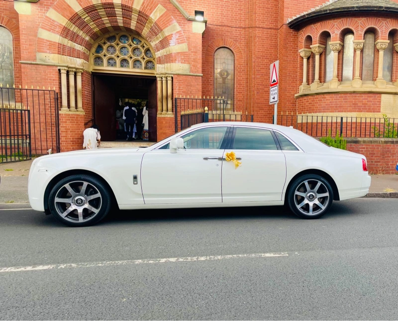 White Rolls-Royce wedding car outside a church for an Altrincham wedding booking